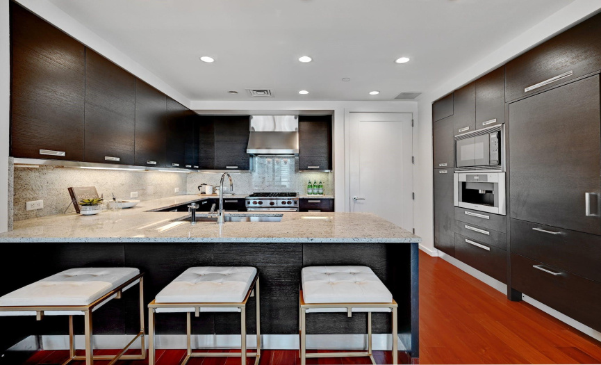The chef's kitchen embodies culinary artistry and modern flair, with granite countertops, a breakfast bar, and sleek stainless steel appliances