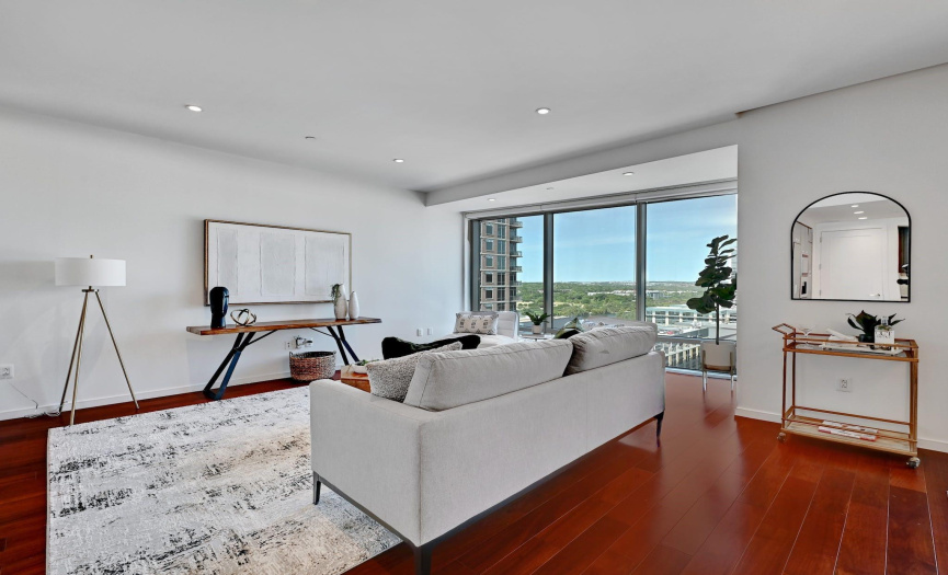 A panoramic wall of windows unveils sweeping vistas of the city and Lady Bird Lake, casting an ethereal glow over the exquisitely designed interior