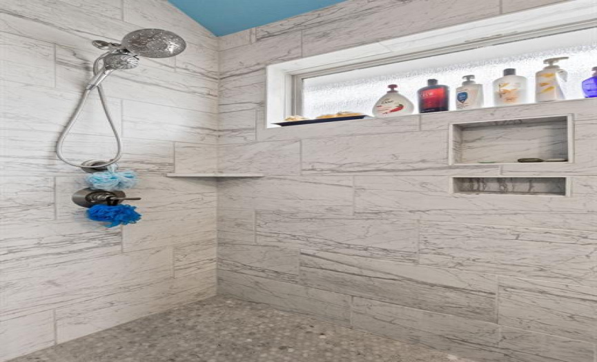 The stunning walk-in shower is wrapped in designer tile.