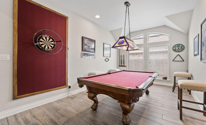 This sophisticated game room is situated along the long entryway and features soaring ceilings, recessed lighting, and a huge picture windows. This would also make a lovely formal dining room. 