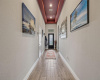To the left of the beautiful long entryway, a sweeping archway opens into a hallway with two of the secondary bedrooms and one of the full secondary bathrooms. 