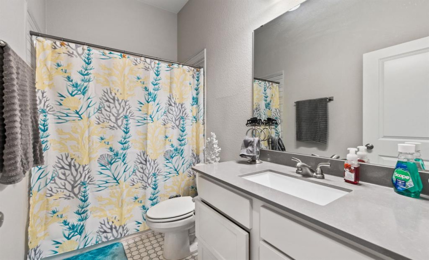 The full guest bathroom offers a spacious vanity and shower/tub combo. 