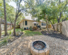 Backyard oasis with deck, firepit, beautiful trees and storage shed.