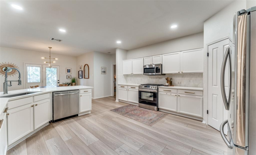 Extra large kitchen with updated appliances, refreshed cabinets, tile backsplash, and gorgeous quartz countertops. 