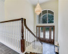 Entry foyer with high ceiling and large chandelier.