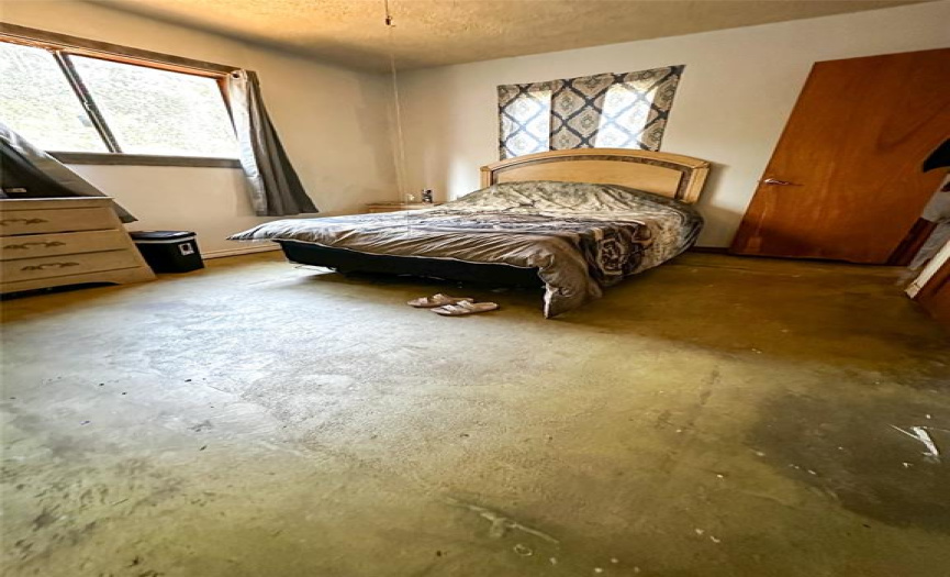 Bedroom 2 on main, raw concrete floors ready for you to install your favorite flooring. 