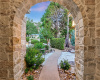 From a front courtyard, step through this arched entry, into a private guest suite.