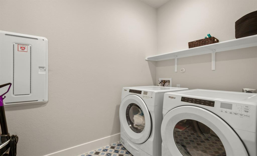 The laundry room is equipped with built-in shelving for accommodate all of your storage needs.