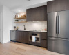 Sleek stainless steel appliances include a dishwasher, built-in oven, electric cooktop and refrigerator