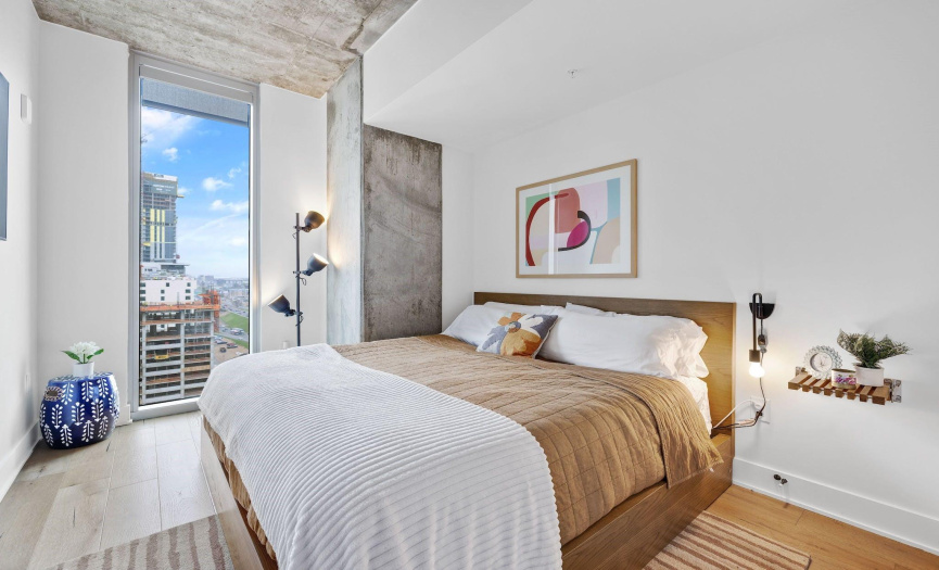 The beautifully furnished bedroom features high ceilings with outstanding views of downtown Austin.