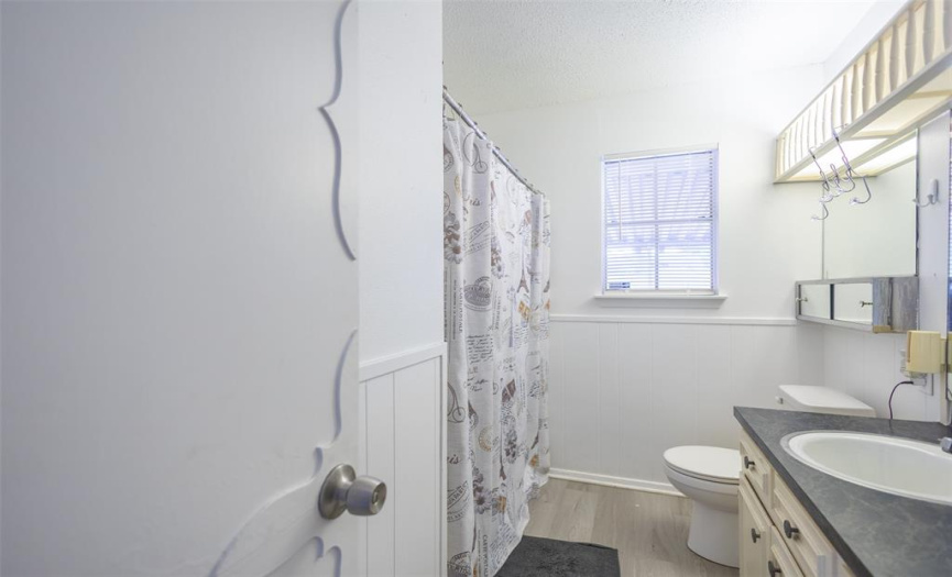 This full bathroom offers a lovely vanity, a window, and a bathtub/shower combo.