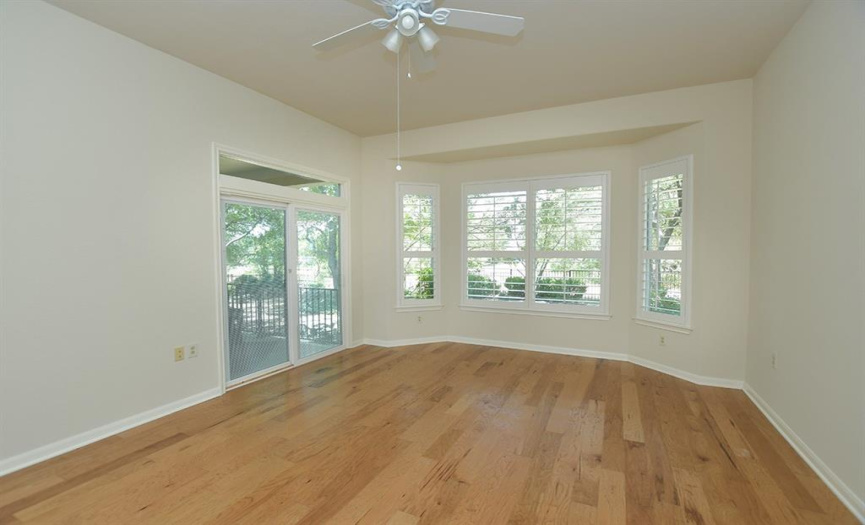 In the primary bedroom a full-view sliding door makes access to the back porch easy.  Large plantation shutters accentuate the view of the fenced & wooded back yard from the bay window.