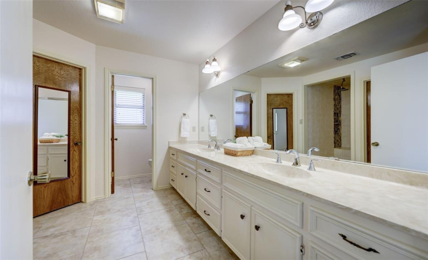 Large primary bathroom with 2 walk in closets and a walk in shower.