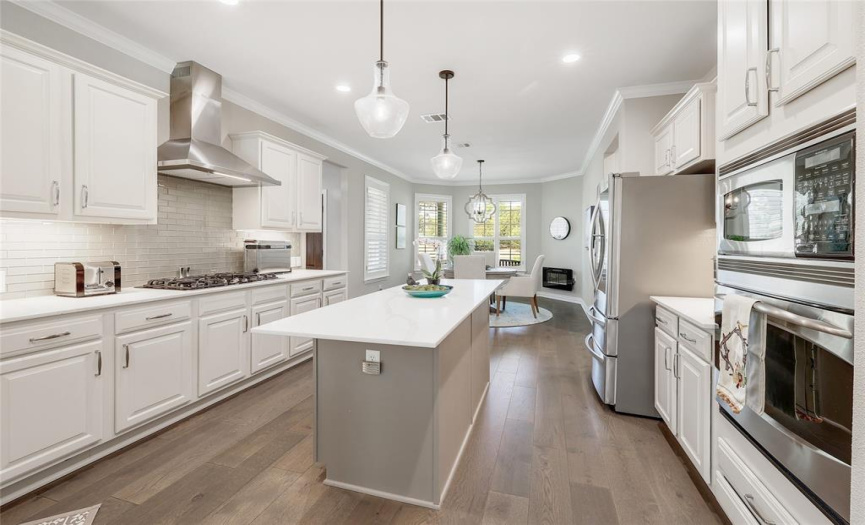 Kitchen features include built-in stainless appliances, a granite top center island with storage.