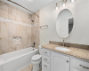  Outfitted with engineered stone counters, a beveled oval mirror, and combination bathtub/shower accented with stylish stacked mosaic tile, the upstairs bathroom has ample room to share.