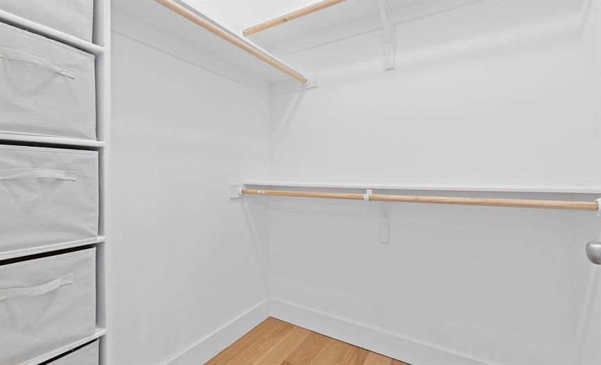 The walk-in closet includes extra storage bins and multiple hanging rods for your organization needs.