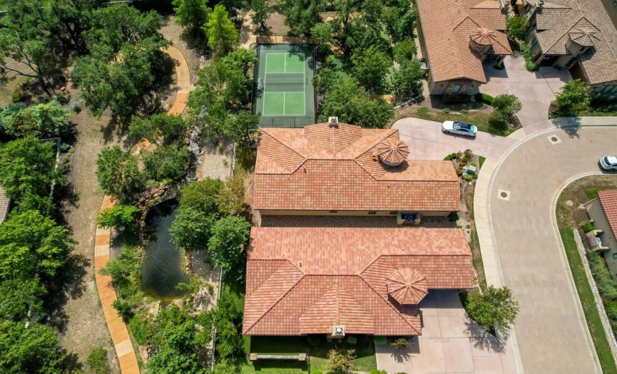 An aerial view of the 2 mile walking path, bubbling river, and pickle ball courts in relationship to the home that is one home removed from the courts. 