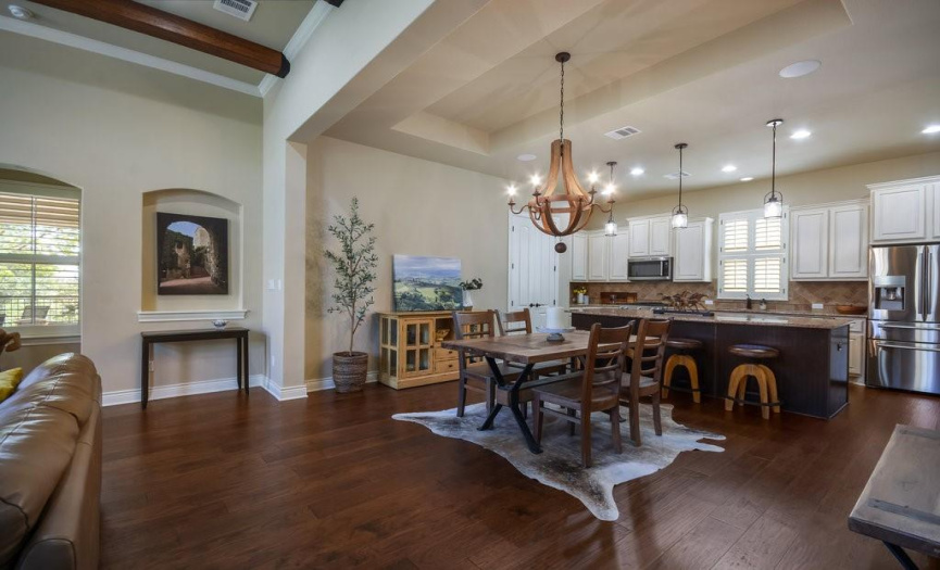 The large expanse of living area is enhanced with wood beams and various ceiling treatments.