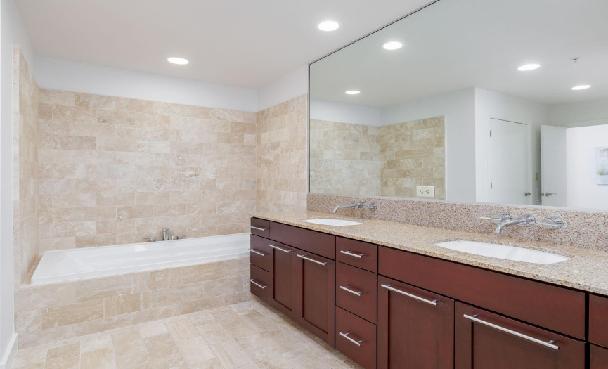 Large soaking tub and double vanity with ample storage.