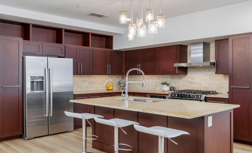 Large kitchen island with granite countertops allow guests to await your culinary creations.