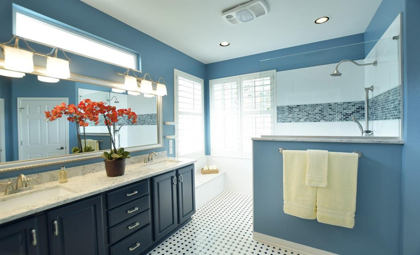 An updated primary bath includes a walk-in shower, quartz counter tops with rectangular sinks and fun floor tile!