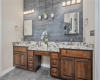 Primary bath with dual sinks, quartz countertops, stone accent wall, and vanity. 