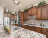 Spacious kitchen with oversized silver and gold veined rich quartz countertops, farm sink, stainless steel appliances, and gas cooktop