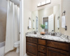 Full bath #3 located upstairs with dual sinks, quartz countertop and designer lighting fixtures