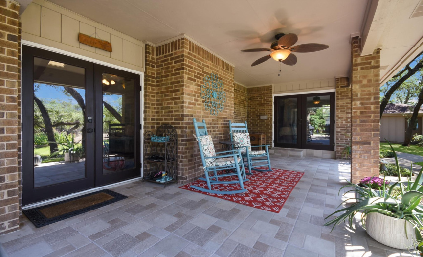 Covered back patio with tiled floor and ceiling fan.