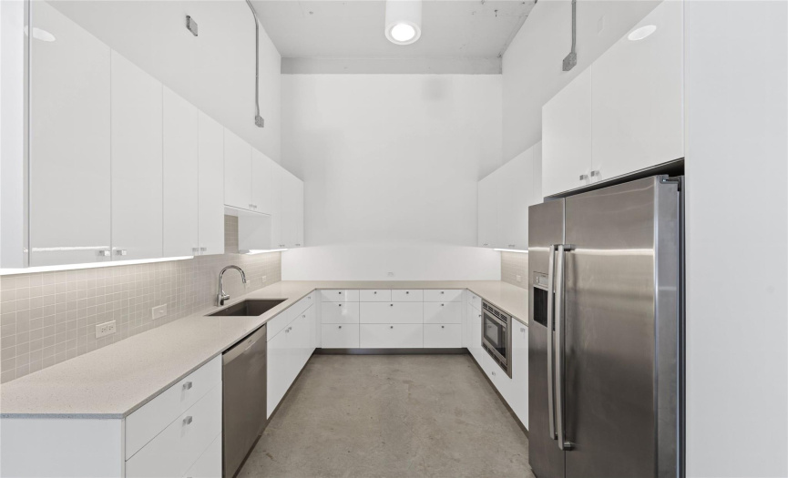 The kitchen area features a modern and minimalist aesthetic, with clean lines and a neutral color palette. The open layout encourages a fluid transition between work and kitchen areas, making it easy for residents to prepare meals while staying connected to their workspace.