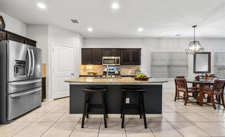 The kitchen offers a modern design with a center island and convenient breakfast  bar.