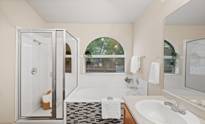 The ensuite is equipped with a relaxing soaking tub and a separate walk-in shower.