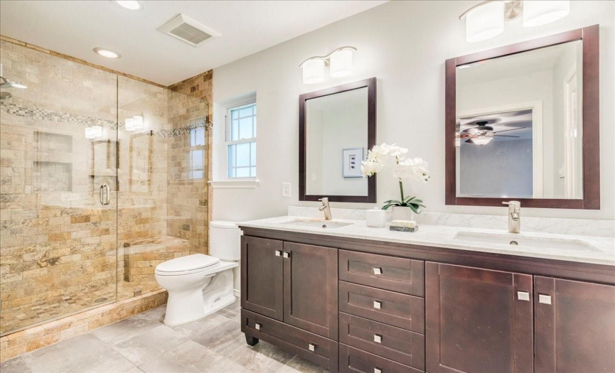 Well-updated primary bath with walk-in frameless glass shower and double vanity!