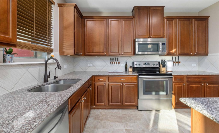 The home chef will love the sleek SS appliances, granite countertops, well-maintained cabinetry, tile backsplash, and large walk-in pantry.