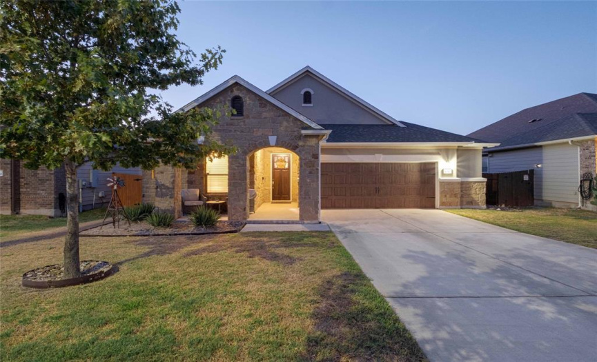 Stunning curb appeal with striking stone masonry, well-maintained landscaping, double archways over the front porch, and a sophisticated garage door. 