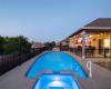 The spectacular in-ground pool offers a serene waterfall feature and is fully fenced-in with wrought iron fencing so you can enjoy unobstructed views. 