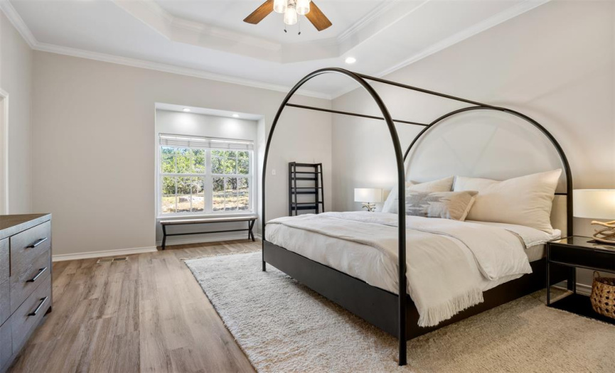 The oversized master suite has two closets, a sitting nook, and a terraced ceiling.  