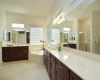 Generous vanities separated by a corner jetted tub are found in this primary bath.