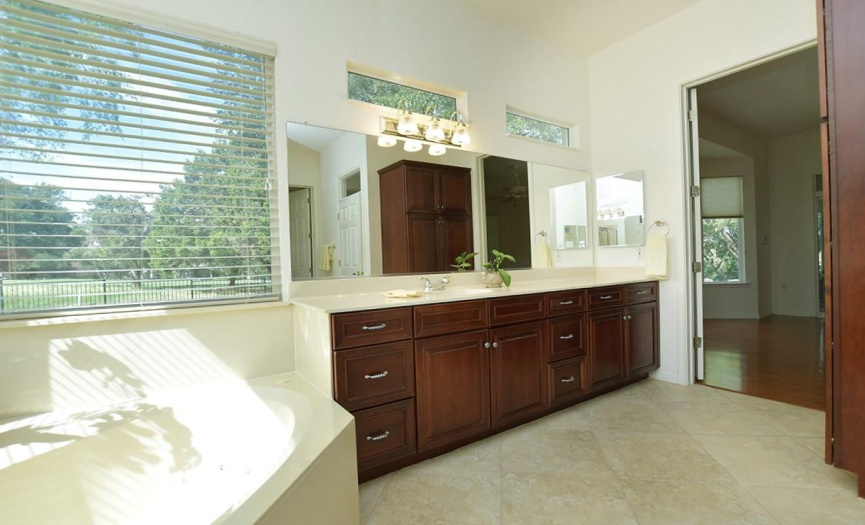 Sunny & bright, the primary bath gets light from two large corner windows as well as upper transom windows.