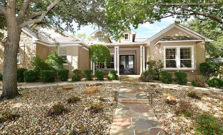A nicely shaded yard surrounds this lovely home.  The stamped concrete sidewalk makes an attractive walk-up.