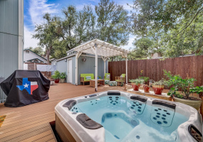 Relax on your spacious composite deck that features a hot tub, custom cabinetry, integrated lighting and pergola!