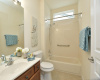 The guest bath with transom window is located off the main hallway, mere steps from one of two guest bedrooms.
