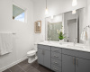 The primary en-suite bathroom offers modern amenities, including a quartz-topped dual vanity.