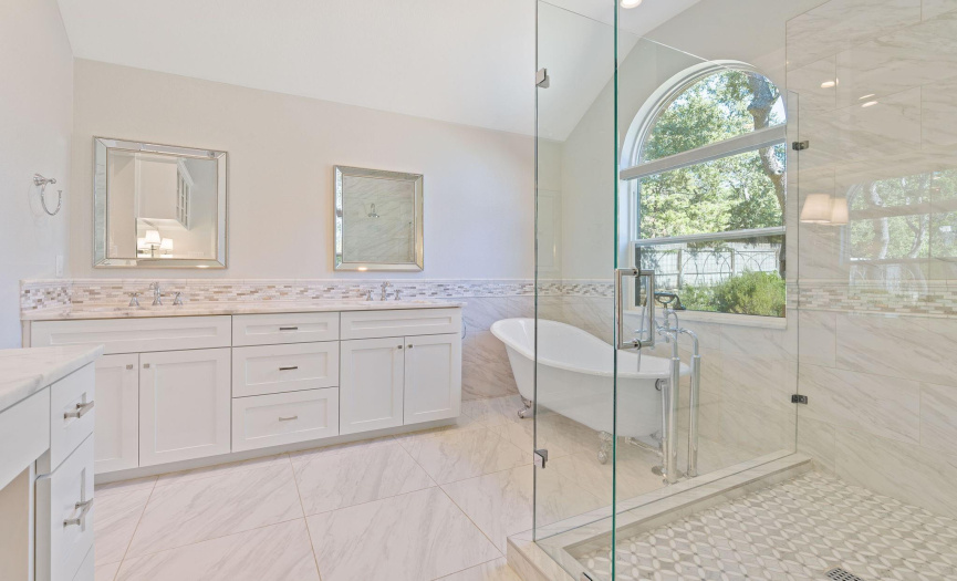 A luxurious primary bath with a spacious shower and a claw foot tub