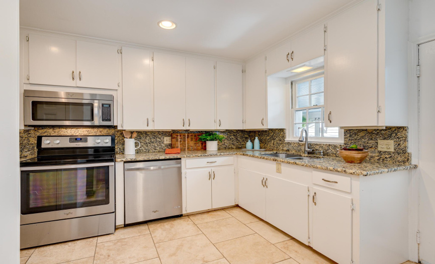 Updated kitchen with granite counters and backsplash and stainless appliances