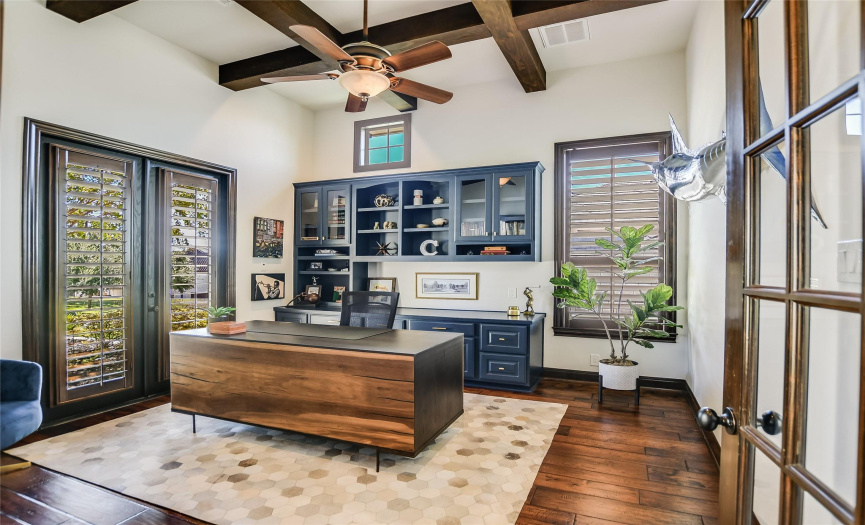 Where productivity meets sophistication: the executive home office is a sanctuary of focus and inspiration. With a wood-beamed coffered ceiling, French doors, and a thoughtfully designed built-in desk and shelving, every workday feels like a masterpiece in the making.