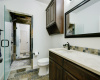 The upper level Jack & Jill bathroom has a shared shower, two separate toilets and two vanities.