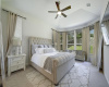 Primary bedroom suite features tall ceilings and large windows overlooking the backyard 