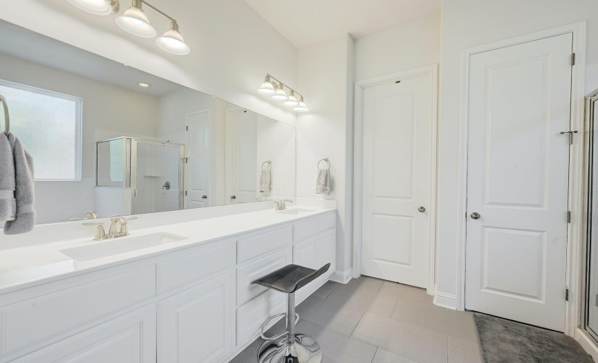 Primary bath features double vanities and amazing lighting