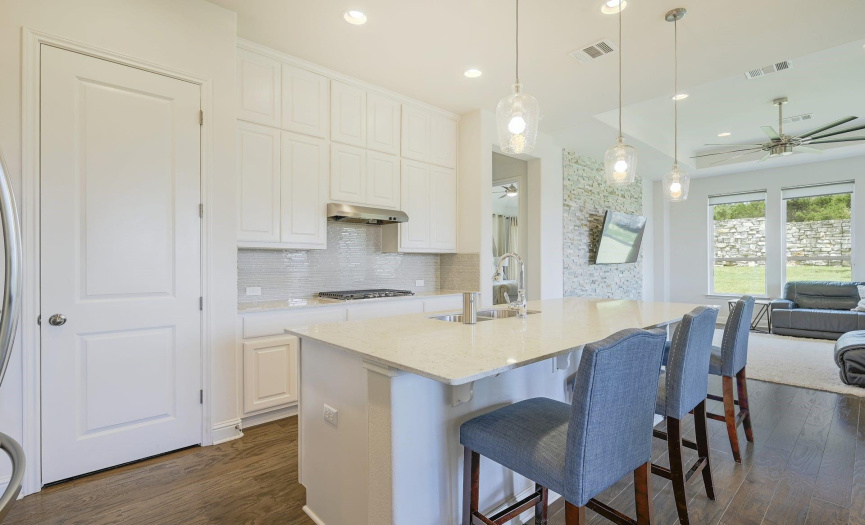 Modern, bright kitchen features extra tall cabinets and additional bar seating or countertop space.